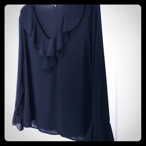 A black ruffled blouse with fluted sleeves